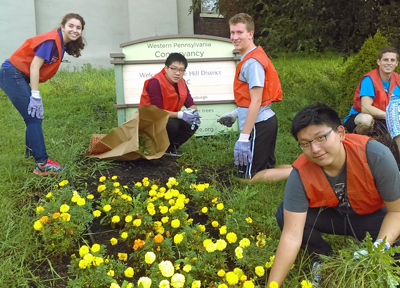 Volunteers weed the community flower garden at Fifth Avenue and Kirkpatrick Street in Oakland/Hill District.