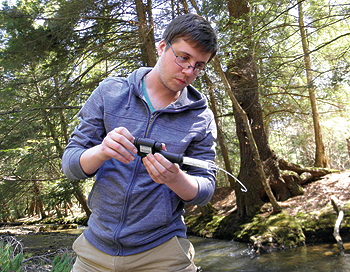 Alex Rudowski, an AmeriCorps watershed 
technician, assesses the water quality 
at a high-value conservation site. 