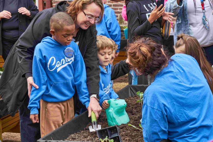 Students and teachers from Conroy Early Childhood Center plant mums and veggies at the Page Street Community Accessible Vegetable Garden opening.