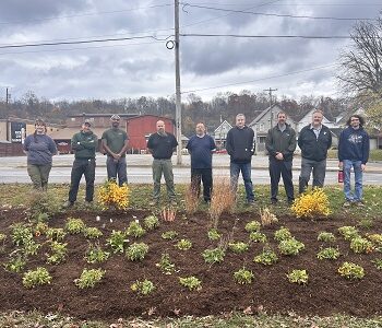 Volunteers and WPC staff stand near a newly planted rain garden in Kittanning near the YMCA.