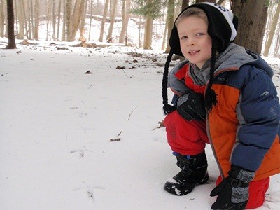 Child with animal tracks in snow