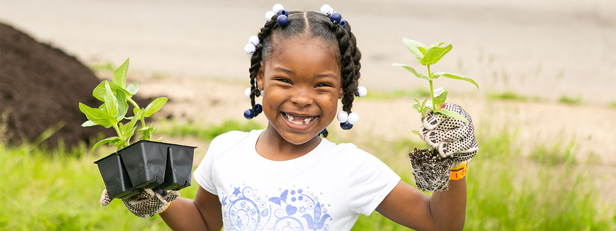 Spring planting young girl holding young saplings